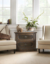 Hooker Furniture Sanctuary Spindle Back Arm Chair, two beige upholstered arm chairs with nailhead trim flanking a wooden side table with decorative vases and a large potted plant in a bright, airy room