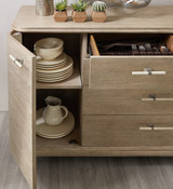 Hooker Furniture Affinity Server, close-up of the light wood finish, open cabinet showing stacked bowls and plates, with cutlery drawer and decorative items on top.