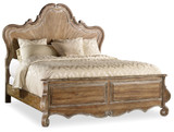 Hooker Furniture Chatelet California King Wood Panel Bed, rustic wooden bed with ornate carved headboard and footboard, with beige and cream bedding and pillows.