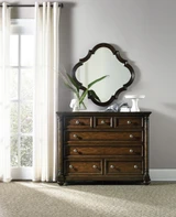 Hooker Furniture Leesburg Bureau, wooden dresser with drawers, antique-style furniture, dark wood finish, decorated with a plant, a skeleton bust figurine, and a ceramic dish on top, reflected in a decorative mirror.