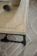 Hooker Furniture Ciao Bella Cocktail Table, distressed wood top with a rustic finish and turned black wooden legs.