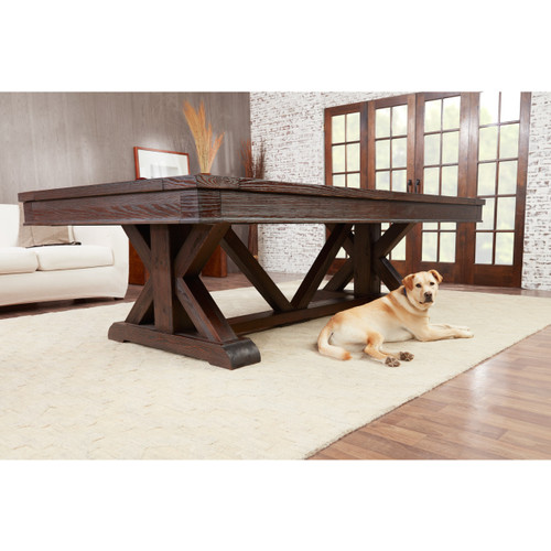 Playcraft Brazos River 8' Slate Pool Table, weathered black finish, situated in a cozy living room with large windows, a white sofa, and a dog lying on the carpet.