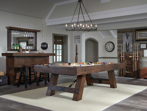 American Heritage Billiards American Heritage Savannah Pool Table – Sable Finish, in a stylish game room with a modern rustic decor, featuring a brown wooden pool table with colorful billiard balls, a wooden computer bar, and decorative elements.