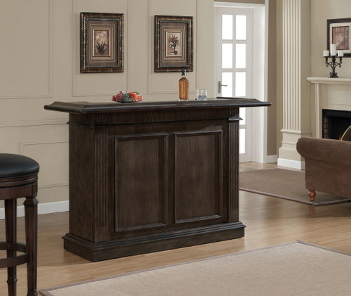 American Heritage Billiards Valore Home Bar, a dark wood home bar with paneled doors, in a living room with beige walls and framed artwork.