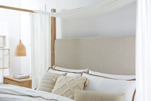 Hooker Furniture Retreat Pole Rattan Cal King Light Wood Upholstered Poster Bed w/Canopy, image of a bedroom featuring a light-colored upholstered poster bed with a canopy and wooden poles, decorated with neutral textiles and natural light.