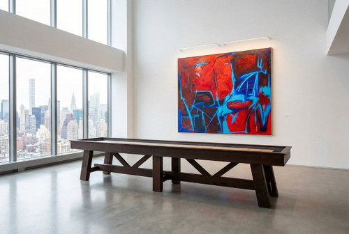 C.L. Bailey Tunbridge Shuffleboard in Weathered Brown, an outdoor game table placed in a modern indoor space with large windows, a colorful abstract painting on the wall, and a view of a city skyline in the background.