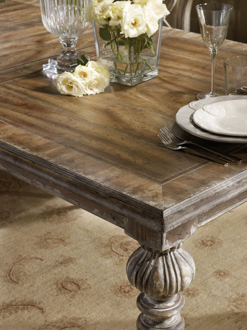 Hooker Furniture Chatelet Rectangle Leg Dining Table with Two 18'' Leaves, rustic wooden dining table with decorative turned leg design, set with white plates, silverware, and glassware, and interior decor including flowers in a glass vase.