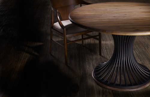 Hooker Furniture Studio 7H Cinch Round Dining Table, image of a round wooden dining table with a unique black curved base and a wooden chair with a cushioned seat.