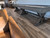 Plank & Hide Co Plank & Hide Otis Pool Table & Shuffleboard, a rustic wood-colored pool table and shuffleboard game in a living room with wooden flooring.