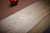 Brunswick Billiards Brunswick Matanza Slate Pool Table - Sandwash Finish, close-up view showing the textured sandwash wooden surface and a small metal plaque.