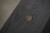 Doc & Holliday Dallas Slate Pool Table, close-up of the dark wooden surface with a silvermed coin emblem.