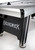 Brunswick Billiards Brunswick V-Force 2.0 Air Hockey Table - 7' Indoor Game Table, close-up view showing the sleek black and silver finish, premium design, and smooth playing surface with bumper rails.