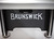 Brunswick Billiards Brunswick V-Force 2.0 Air Hockey Table - 7' Indoor Game Table, black surface with large white Brunswick logo, sturdy legs with circular supports.