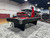Brunswick Billiards Brunswick Black Wolf Slate Pool Table, modern black and gray pool table with a red felt surface and cue sticks in a showroom setting.