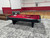 Brunswick Billiards Brunswick Black Wolf Slate Pool Table, sleek black pool table with red felt in an indoor sports facility.