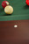 Brunswick Billiards Brunswick Henderson Pool Table in Espresso, showing the felt surface and the corner pocket hole with billiard balls on the green felt.