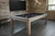 Brunswick Billiards Brunswick Sanibel Slate Pool Table in Rustic Grey, image of a stylish pool table with a black playing surface, wooden frame, and rugby balls, in a modern industrial game room.