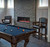 Brunswick Billiards Brunswick Traditional Player’s Chair in Espresso finish, placed in a game room with pool table and a modern fireplace with stone wall.