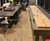 Plank & Hide Co Isaac Shuffleboard Table, wooden shuffleboard with markings and pucks, placed in a cozy indoor space with a dining area and comfortable seating.