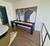 Plank & Hide Co Fulton Shuffleboard Table in Black Finish, modern indoor game furniture with sleek black frame and wooden surface, set against an artful wall in a contemporary living space.