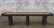 Venture Shuffleboard Challenger Sport Shuffleboard Table, long rectangular game table with a wooden playing surface and dark brown frame, set against a brick wall background.