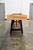 Venture Shuffleboard Astoria Sport Shuffleboard Table | Custom USA, front view of the shuffleboard table with wooden playing surface and black sturdy legs in an industrial setting.