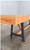 Venture Shuffleboard Astoria Sport Shuffleboard Table, close-up of wooden top and black leg supports on a polished concrete floor.