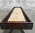 Venture Shuffleboard Williamsburg Shuffleboard Table, featuring a wooden playing surface with scoring sections and a dark wooden frame, made in USA.