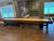 Playcraft Santa Fe Shuffleboard Table, a wooden shuffleboard table with a polished surface, in a game room with artwork and a large window.