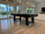 Plank & Hide Co Isaac Pool Table Distressed Black & Gold, modern black pool table in a spacious living room with large windows and light-colored wooden floors.