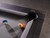 Plank & Hide Co Beaumont Pool Table by Plank & Hide with distressed black finish, close-up of corner detail showing felt surface and pool balls.