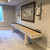 Playcraft Montauk Shuffleboard Table by Playcraft – White Wash Finish, 9' & 12' with wooden surface and black scoring rails in a game room setting.