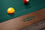 Brunswick Billiards Brunswick Winfield Slate Pool Table, Nutmeg Finish, close-up of the green felt surface and billiard balls with a heritage logo on the wood frame.