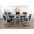 Sawyer Twain Henry 5-Piece Poker & Dining Table Set with Chairs, weathered grey color, round table with a pedestal base, surrounded by five comfortable chairs with black upholstery and armrests, decorated with a black vase with pink flowers and a tall potted plant in the background.