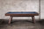 Doc & Holliday George Slate Pool Table in Antique Coffee, a stylish and modern pool table with a wooden frame and slate playing surface, set against a textured white brick wall.