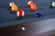 Doc & Holliday George Slate Pool Table in Antique Coffee, featuring a close-up of the pool table with colorful billiard balls arranged on the dark slate surface.