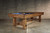Doc & Holliday Churchill Slate Pool Table, rustic wooden pool table with a slate surface and pool balls racked, in a minimalistic room setting.