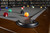 Doc & Holliday Scholar Pool Table by Doc & Holliday, a professional billiards table with a grey felt surface and colorful billiard balls arranged for a game, in a room with a dark wooden border and a bookshelf in the background.