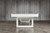 Doc & Holliday Santorini Pool Table, modern white dining top pool table with minimalist design in a room with grey wooden wall background.