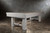 Doc & Holliday Churchill Pool Table, made in USA, showcasing a sturdy wooden frame with a rustic finish on a concrete floor against a textured wall.