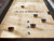Plank & Hide Co Isaac Pool Table & Shuffleboard Combo, close-up image showing shuffleboard with colored puck markers and the Plank & Hide Co logo on the wooden surface.