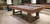 Plank & Hide Co Plank & Hide Isaac Slate Pool Table, wooden pool table with a slate surface and black pockets, shown in an indoor setting with a modern background.