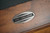 Doc & Holliday Scholar Slate Pool Table, close-up of the metal manufacturer badge on the wooden surface of the pool table.