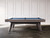 Doc & Holliday Scholar Slate Pool Table, custom made in the USA, featuring a sleek gray wooden frame and blue felt surface in a minimalist room setting.