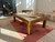Brunswick Billiards Brunswick Parsons Pool Table in Natural Dry Oak, indoor setting with sunlight, with pool cues on top.