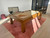 Brunswick Billiards Brunswick Parsons Pool Table in Natural Dry Oak, modern wooden pool table with cue sticks on top, positioned on a pink rug in a well-lit game room.