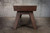 Doc & Holliday George Shuffleboard Table by Doc & Holliday in antique coffee finish, showcasing a wooden shuffleboard table with a sleek, polished surface and sturdy angled legs, set against a concrete wall background.