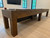 Brunswick Billiards Brunswick Parsons Shuffleboard Table, a large wooden shuffleboard table with a sleek finish in a modern game room.