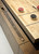 Brunswick Billiards Brunswick Parsons Shuffleboard Table, wooden tabletop with shuffleboard discs and score engraved on the side.
