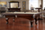 American Heritage Billiards Marietta 8' Slate Pool Table - Sierra Finish, in a stylish game room with hardwood flooring, surrounded by chairs and a bar area.